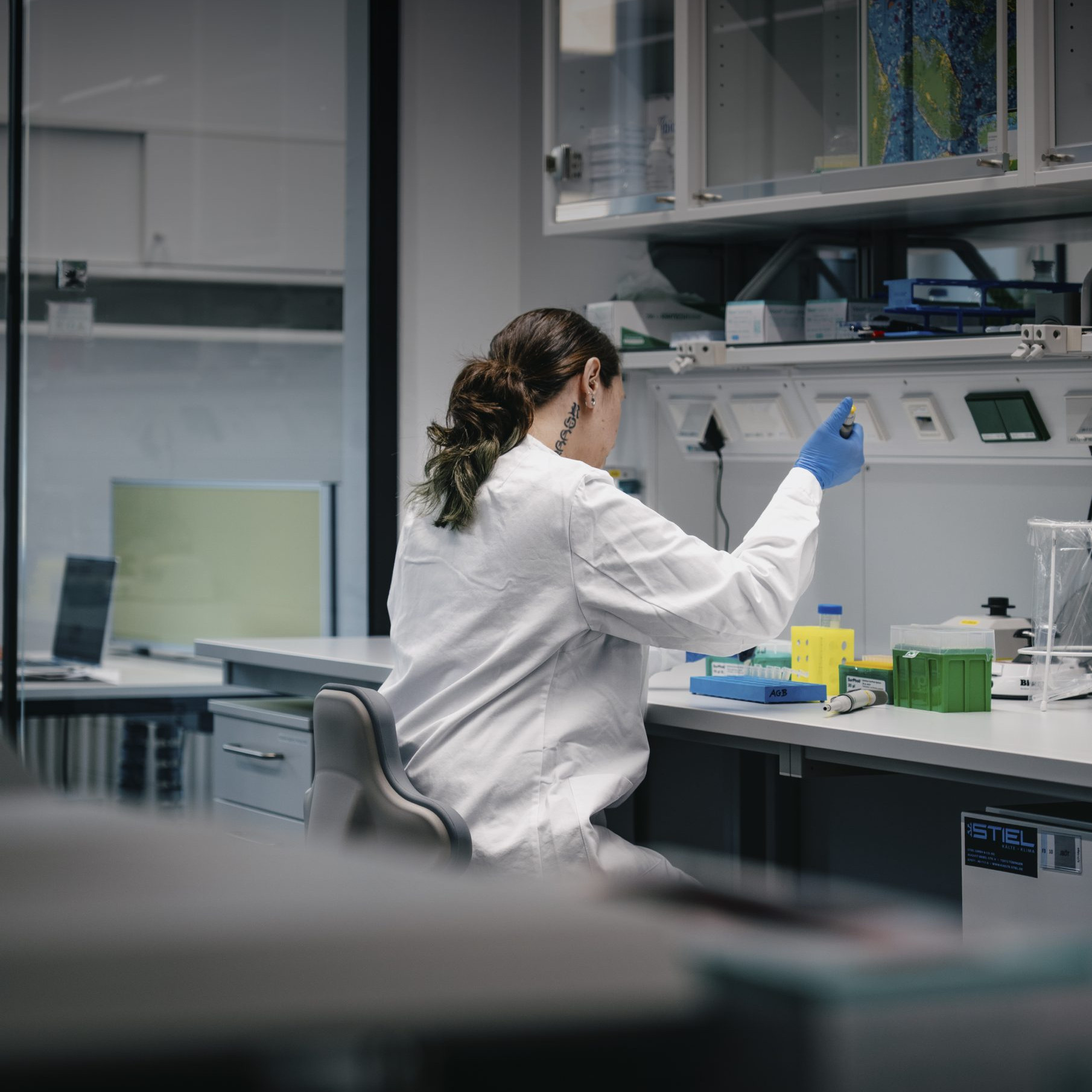 Forscherin bei Laborarbeit mit Pipette am Arbeitsplatz