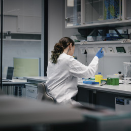 Forscherin bei Laborarbeit mit Pipette am Arbeitsplatz