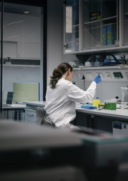Forscherin bei Laborarbeit mit Pipette am Arbeitsplatz