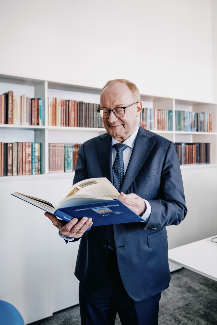 Mann im Anzug liest Buch in einem Büroraum